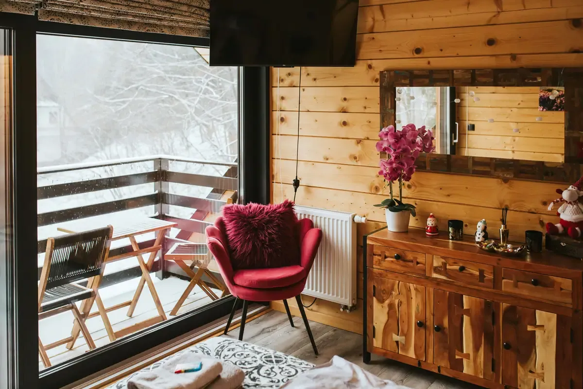 Kącik sypialni z fotelem i widokiem na ośnieżony balkon, Szczyrk